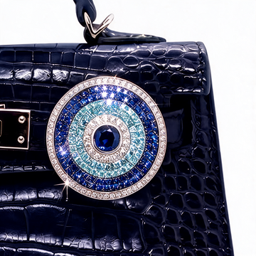 Blue evil eye diamond bag charm in moissanite attached to a navy bag – Zius Jewels